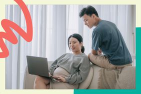 pregnant woman sit on couch with laptop while her husband wathces