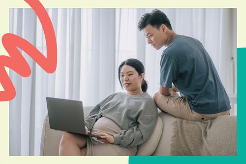 pregnant woman sit on couch with laptop while her husband wathces