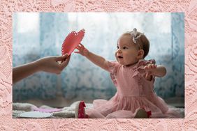 Baby girl reaching for a valentine heart 