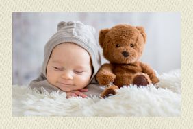 Baby sleeping next to a teddy bear 