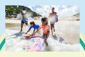 a family with body boards playing on the beach