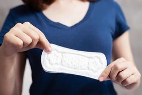 A woman holding a sanitary napkin