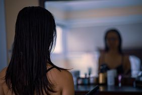 Image of a girl looking in a mirror from behind