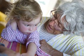 Grandmother talking to toddler granddaughter.