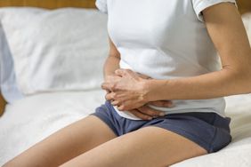 Woman holding stomach with cramp or pain.