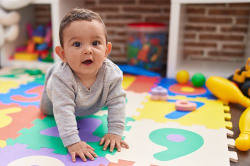 Baby crawling on a play mat