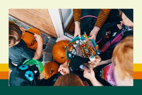 Kids reach into a bowl of Halloween candy as they trick-or-treat. 