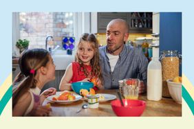 A father and his two daughters sitting at the kitchen table in the kitchen at home. They are eating and enjoying breakfast together while talking.