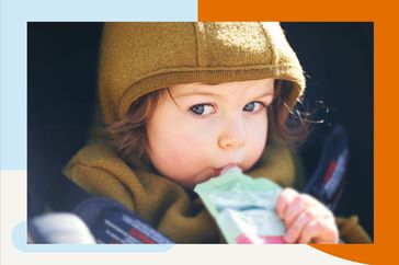 Toddler kid eating fruit puree from a pouch