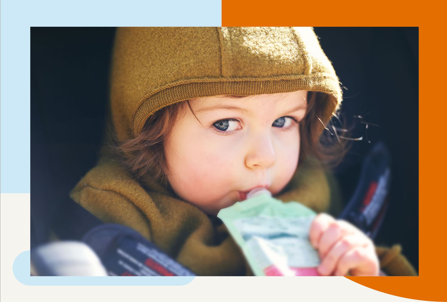 Toddler kid eating fruit puree from a pouch