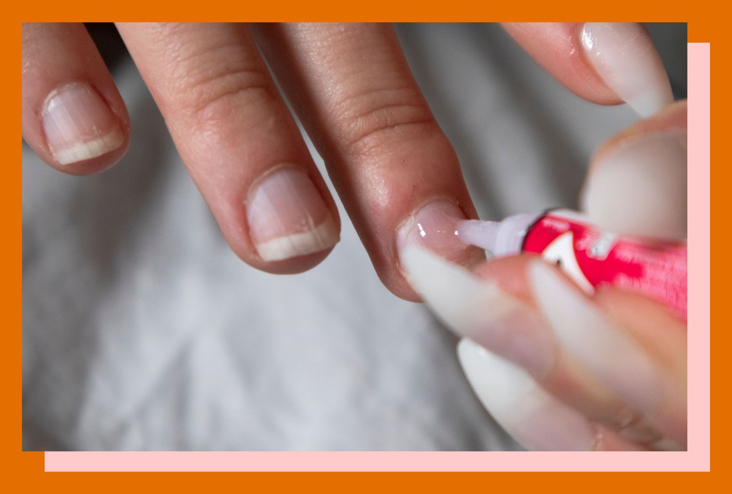 Close-up of a person applying nail glue to affix fake nails.