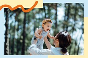 Mom holding up her laughing baby outside