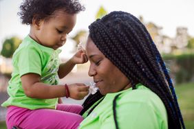 Young woman holding a baby in the park