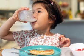 Young Child drinks milk out of a glass.