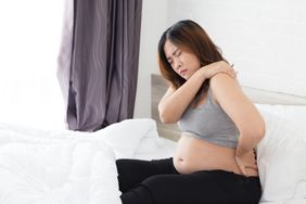 Pregnant person suffering from pain in shoulder and back