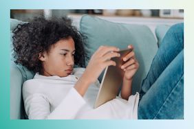 Teen lying on the couch looking at a tablet.