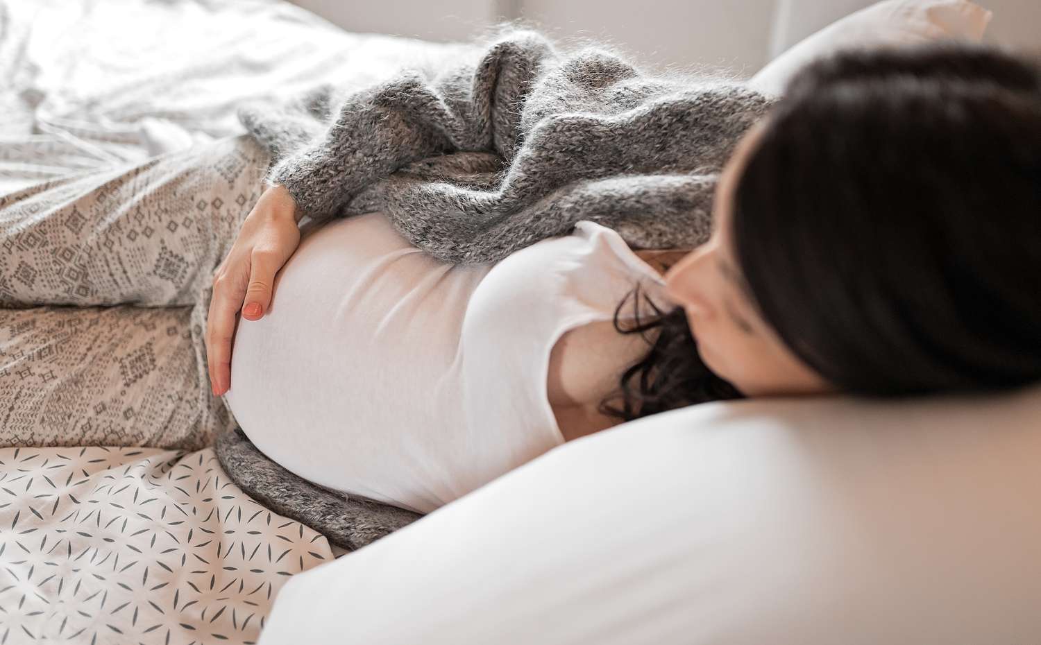 Pregnant woman lying on bed