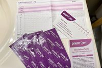 Premom Quantitative Ovulation Test Strips in packaging on a counter with the instruction sheet