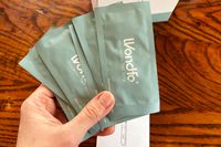 A person holding multiple Wondfo Ovulation Test Strips in their packaging