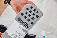 A person holds up a pair of cozy socks from the Bodily Scheduled C-Section Box