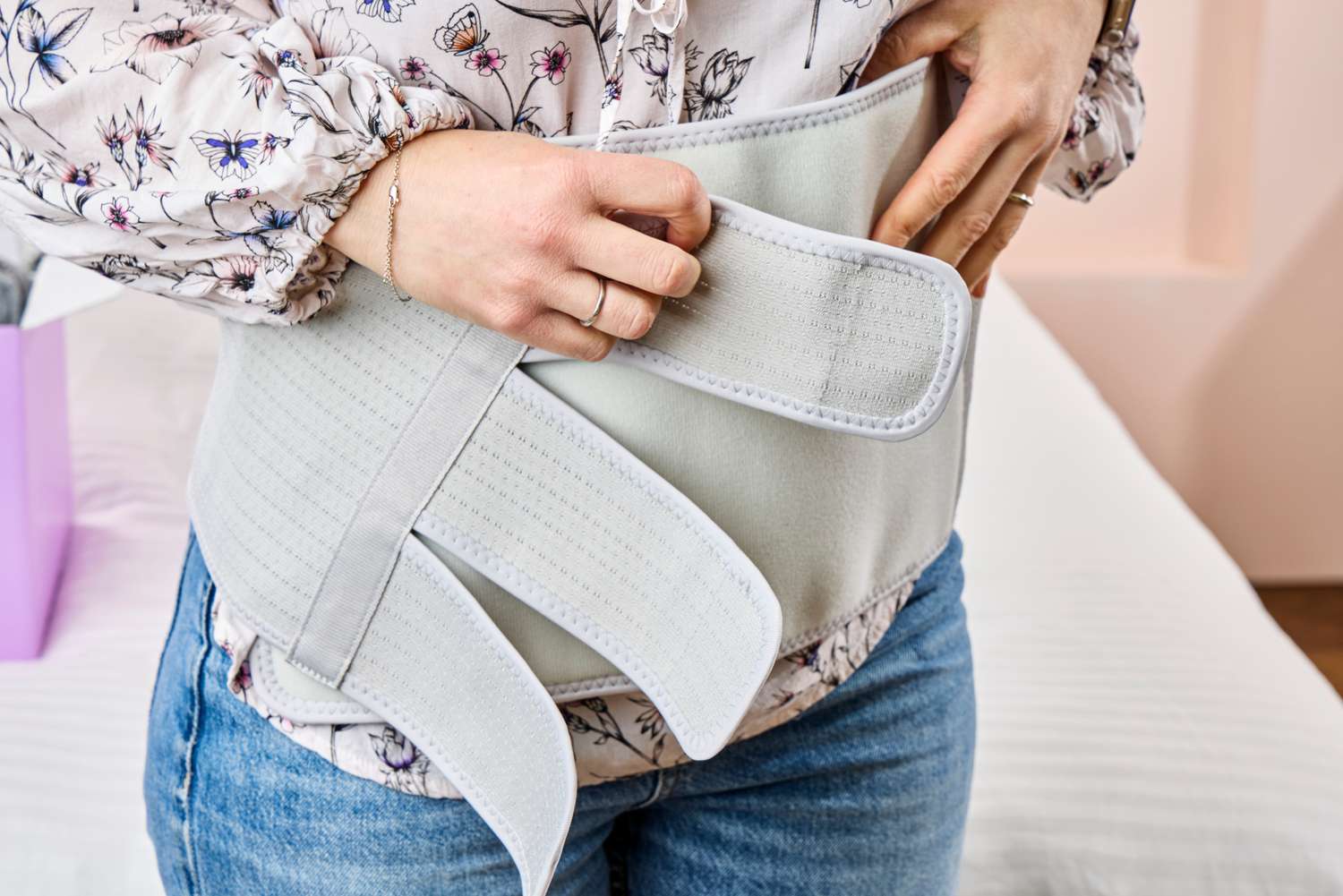 A person tightens the belly binder in the Frida Mom C-Section Recovery Kit