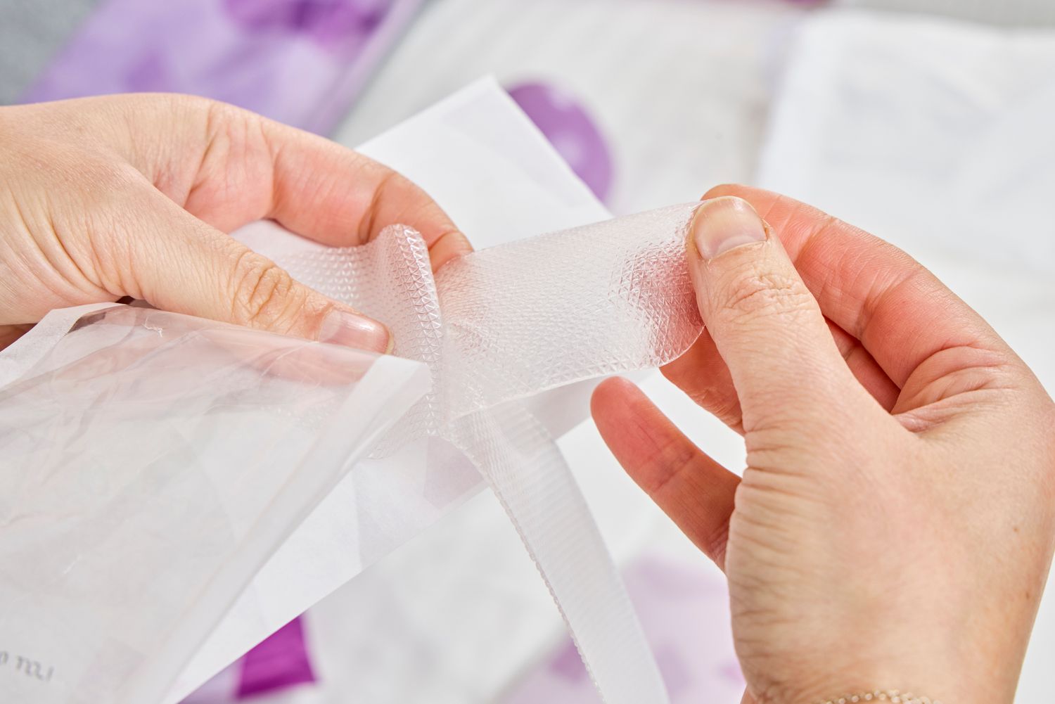 A person touches a silicone scar patch from the Frida Mom C-Section Recovery Kit