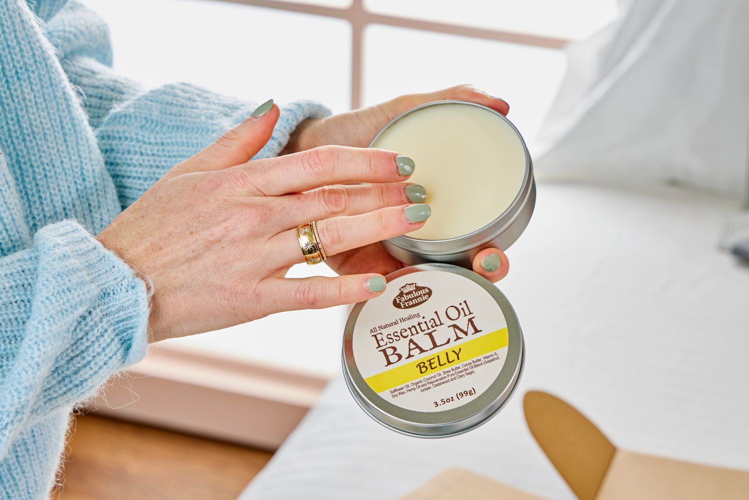 A person touches the essential oil belly balm from the Sunflower Motherhood Deluxe Postpartum Recovery Box