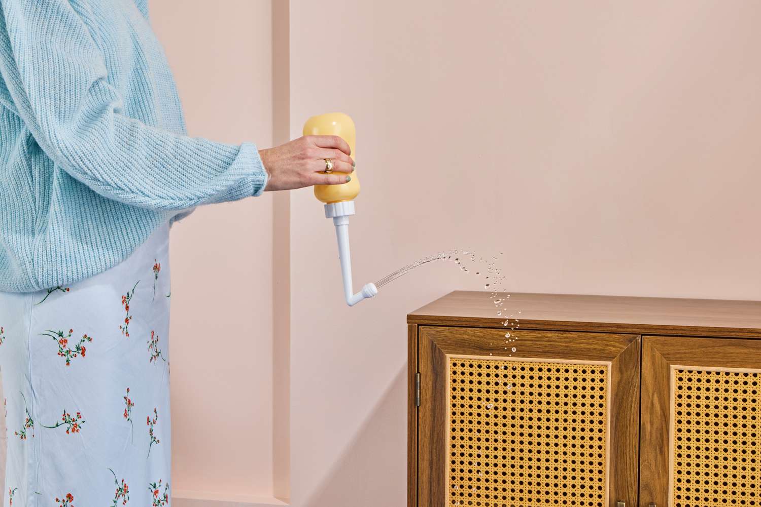 A person sprays water from the peri bottle included in the Sunflower Motherhood Deluxe Postpartum Recovery Box