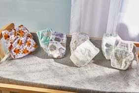 5 sets of diapers laid out on a crib