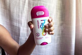 A girl holds up a stick of hello Unicorn Deodorant With Shea Butter