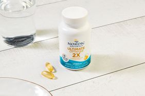 Nordic Naturals Ultimate Omega on a table with a glass of water