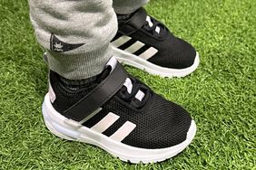 A child wears the Adidas Racer TR 23 Kids' Shoes in grass