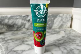 A tube of Tom's of Maine Natural Children's Fluoride Toothpaste on a bathroom counter