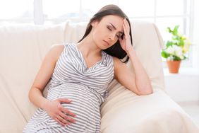 Pregnant woman holding head