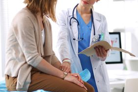 Doctor Talking to Patient Sitting on Table