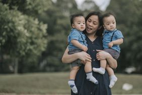 Mother with her twin baby boys at public park