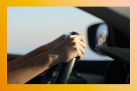 Teenager's hands on a steering wheel driving