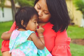 Mother holding her daughter in arms