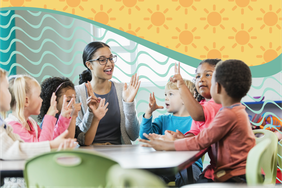 Children gathered around a table with a teacher