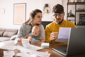 Young parents with a baby looking over finances.